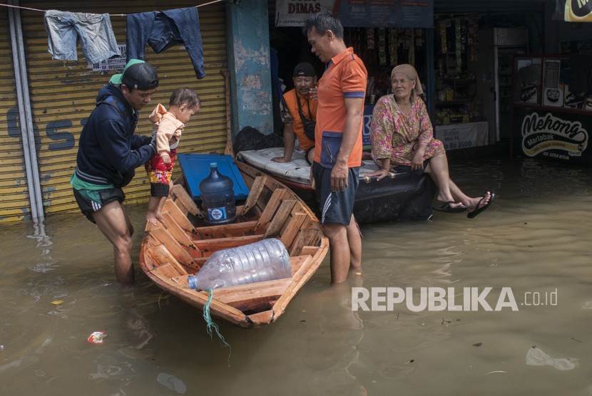 Warga menaikkan balita ke atas perahu untul melintasi genangan banjir luapan sungai Citarum di Kawasan Baleendah, Kabupaten Bandung, Jawa Barat, Jumat (5/4/2019). 