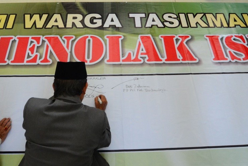 Warga menandatanagi spanduk penolakan keberadaan Negara Islam Irak dan Suriah atau disebut Islamic State of Iraq and Sham (ISIS) di Mesjid Agung Kabupaten Tasikmalaya, Singaparna, Jawa Barat, Jumat (8/8).