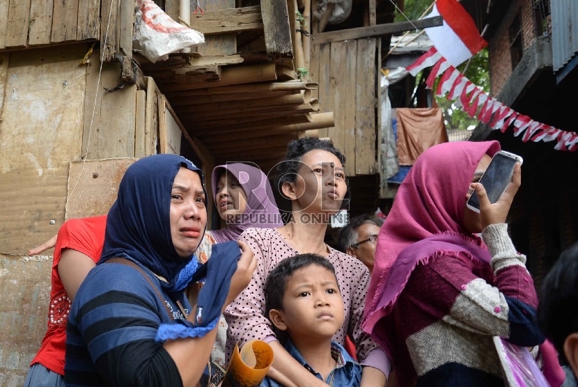 Warga menangis histeris melihat rumah tinggalnya dirobohkan oleh alat berat di permukiman padat di bantaran sungai Ciliwung di Kampung Pulo, Kampung Melayu, Jatinegara, Jakarta, Jumat (21/8). 