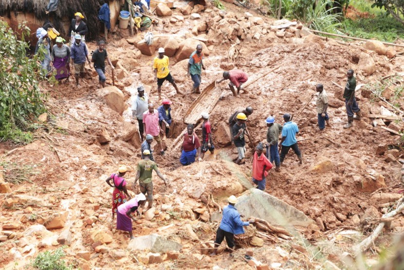 Warga mencari anggota keluarganya yang tertimbun tanah longsor akibat Badai Idai di Chimaniman, sekitar 600 kilometer di tenggara Harare, Zimbabwe, Selasa (19/3).