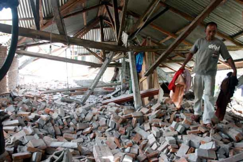  Warga mencari barang miliknya yang masih dapat digunakan di antara puing rumah yang roboh akibat gempa di Desa Selun, Kute Panang, Aceh Tengah, Aceh, Jumat (5/7).