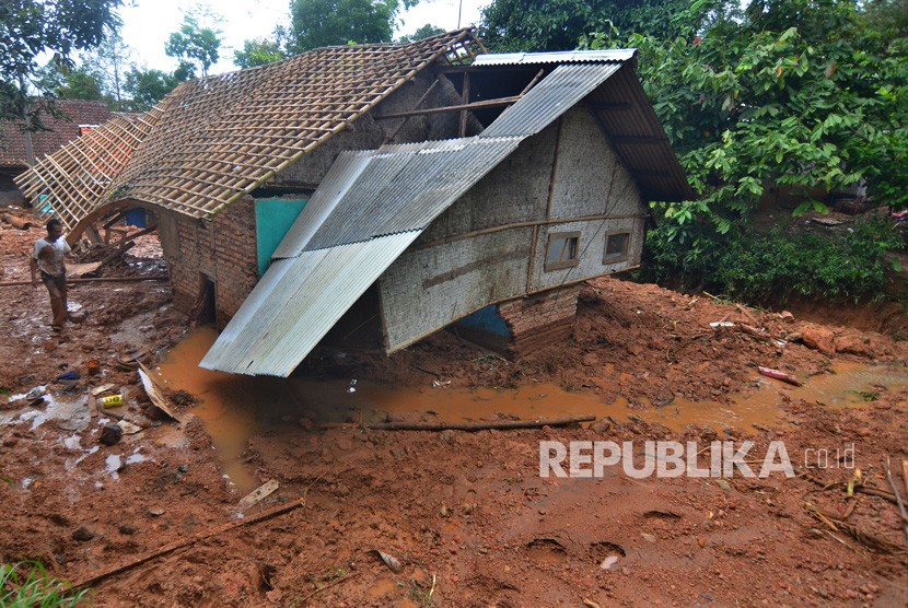 Warga mencari barang yang masih bisa diselamatkan di rumahnya yang tertimbun meterial tanah longsor di Desa Bojongsari, Kabupaten Tasikmalaya, Jawa Barat