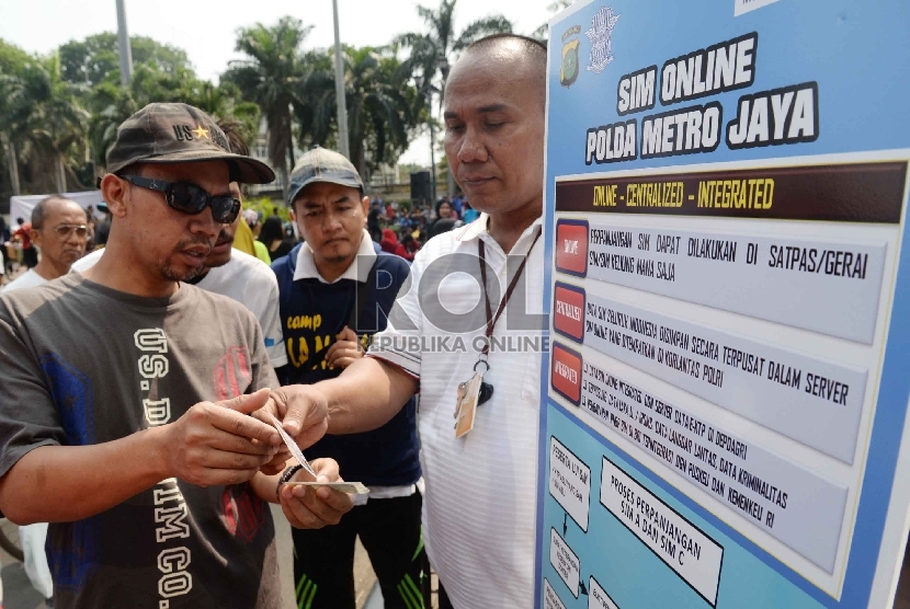  Warga mencari informasi tentang SIM Online saat Hari Bebas Kendaraan Bermotor (HBKB) di Bundaran HI, Jakarta, Ahad (4/10).  (Republika/Yasin Habibi)