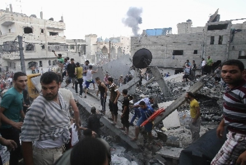 Warga mencari korban di reruntuhan bangunan yang hancur akibat serangan Israel di Rafah, Gaza selatan, Palestina, Jumat (11/7).