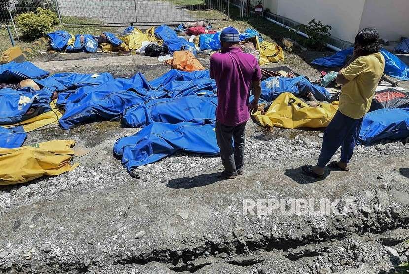 Warga mencari korban gempa dan tsunami yang tewas di RS Bhayangkara, Palu, Sulawesi Tengah, Ahad (30/9). 