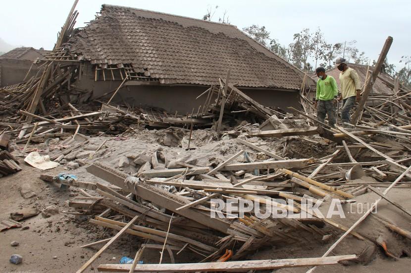 Warga mencari sisa barang dari rumahnya yang hancur akibat erupsi gunung Semeru di desa Supiturang, Lumajang, Jawa Timur, Ahad (5/12/2021). Luncuran awan panas akibat letusan gunung Semeru mengakibatkan puluhan rumah di dua kecamatan rusak dan delapan kecamatan terdampak abu vulkanik. 