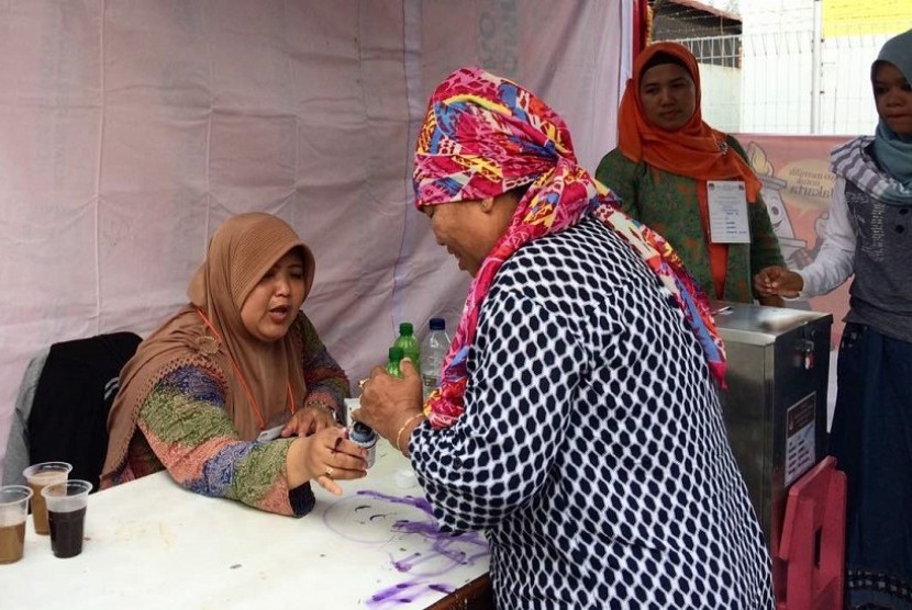 Warga mencelupkan jarinya ke dalam tinta usai melakukan pencoblosan ulang dalam pemungutan suara ulang (PSU) Pilkada DKI Jakarta Sabtu (22/4).