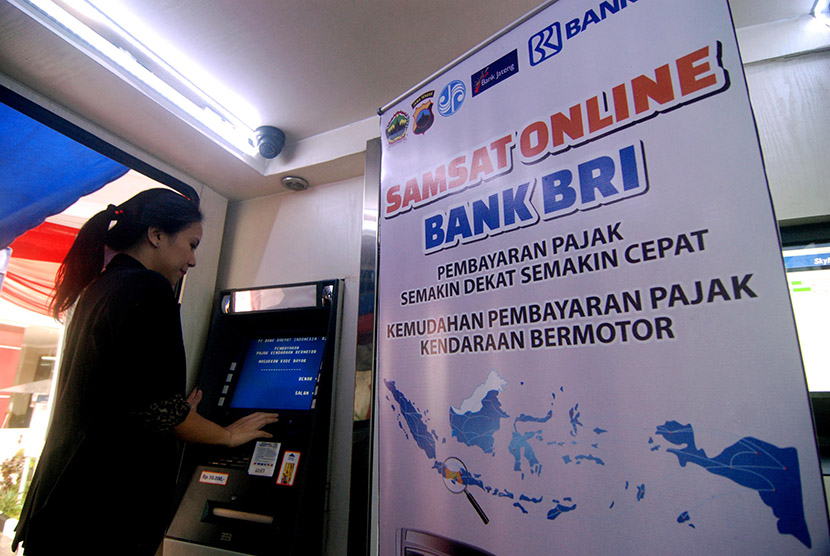 Warga mencoba pembayaran pajak kendaraan bermotor (PKB) melalui mesin anjungan tunai mandiri (ATM) BRI usai diluncurkan di Ungaran, Kabupaten Semarang, Jawa Tengah, Senin (28/12).