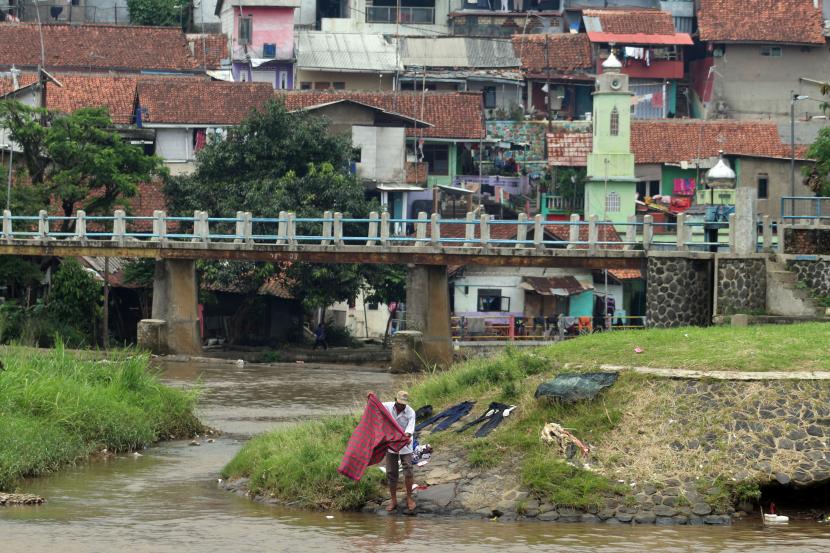 Warga mencuci pakaian di bantaran Sungai Cisadane, Pancasan, Kota Bogor, Jawa Barat, Selasa (30/11/2021). Badan Perencanaan Pembangunan Nasional (Bappenas) menargetkan angka kemiskinan bisa turun 0,5 persen di tahun 2022 dari persentase kemiskinan saat ini yang mencapai 10,14 persen.