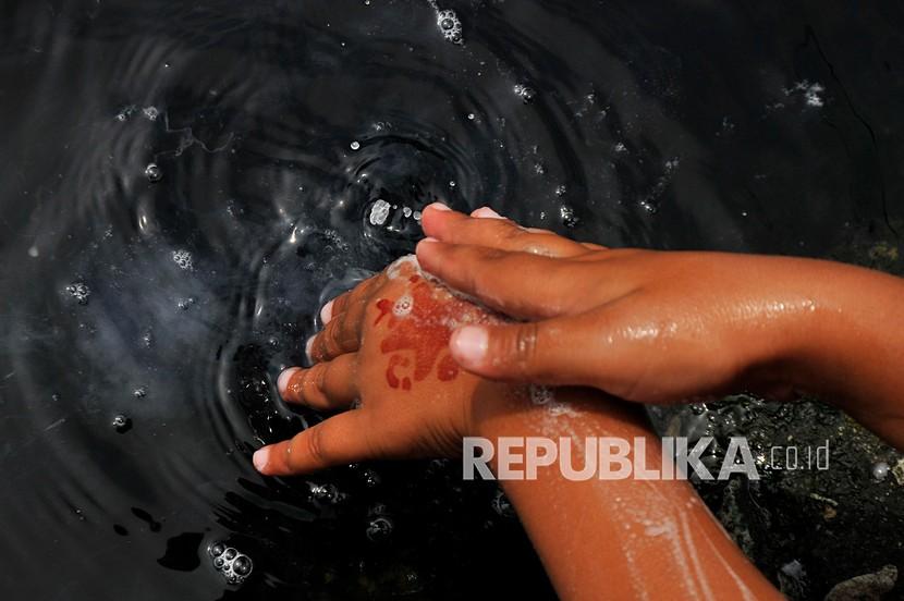 Warga mencuci tangan di aliran Kali Cilemahabang, Karangbahagia, Kabupaten Bekasi, Jawa Barat, Selasa (7/9/2021). Menurut warga, aliran kali tersebut sudah lima tahun tercemar limbah industri yang mengakibatkan warnai air menjadi hitam dan mengeluarkan bau tak sedap.