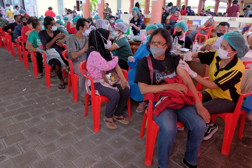 Warga mendapatkan suntikan vaksin COVID-19 dosis ketiga saat vaksinasi booster massal di Vihara Satya Dharma, Denpasar, Bali, Senin (28/3/2022). Kegiatan yang digelar Badan Intelijen Negara (BIN) tersebut untuk mempercepat pencapaian vaksinasi booster di Bali dan setiap warga yang telah divaksin dosis ketiga, akan mendapatkan minyak goreng gratis. 