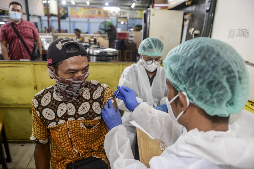 Warga mendapatkan suntikkan vaksin COVID-19 di Pusat Jajanan Serba Ada di kawasan Pendurenan, Jakarta, Jumat (20/8/2021). Layanan vaksinasi malam hari dilakukan untuk menjangkau masyarakat yang memiliki kesibukan di siang hari itu guna mempercepat target kekebalan komunal atau 