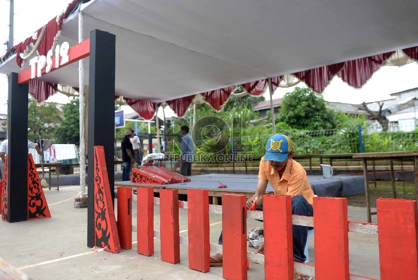 Warga mendirikan TPS 12 jelang Pilkada Serentak di Depok, Jawa Barat, Selasa (8/12).  (Republika/Wihdan)