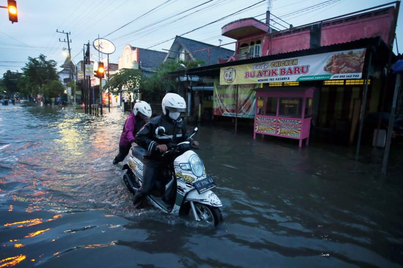Warga mendorong kendaraannya yang mogok saat banjir di kawasan Sutojayan, Blitar, Jawa Timur. Pemprov Jatim mencatat ada 13.875 hektare lahan pertanian yang terdampak bencana.
