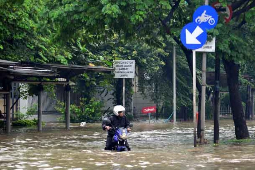Warga menembus banjir di Cempaka Putih, Jakarta, Kamis (17/1). 