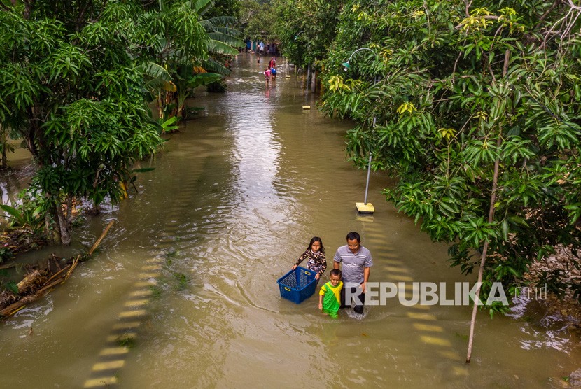 Warga menembus jalan desa yang terendam banjir akibat Sungai Tuntang jebol di Desa Trimulyo, Guntur, Kabupaten Demak, Jawa Tengah, Jumat (10/1/2020). BPPT siap membantu pemerintah daerah menyiapkan peringatan dini banjir.