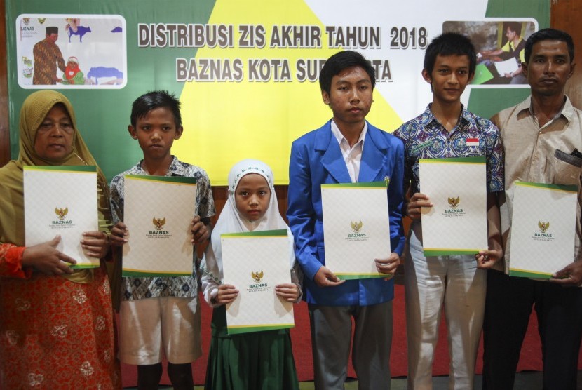 Warga menerima Zakat, Infaq dan Sedekah (ZIS) dari Badan Amil Zakat Nasional (BAZNAS) Solo di Balaikota Solo, Jawa Tengah, Kamis (20/12/2018). 