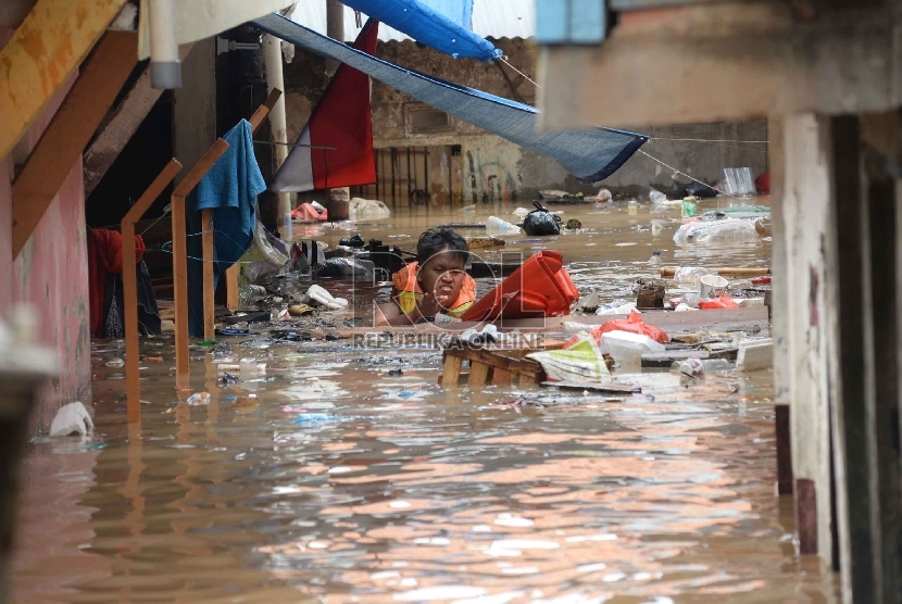Warga menerobos air banjir yang menggenangi Kampung Pulo, Jakarta, Senin (16/11). (Republika/Yasin Habibi)