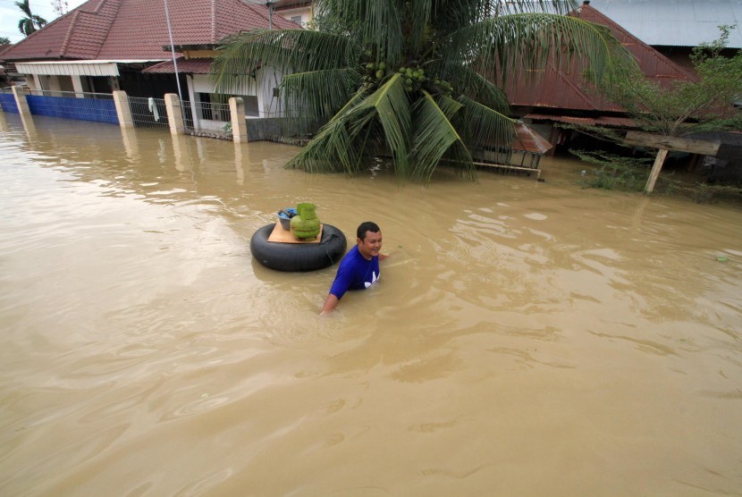 Warga menerobos banjir di Kecamatan Lhoksukon, Aceh Utara, Aceh, Selasa (5/12). Tidak hanya di Aceh, bencana banjir juga melanda beberapa wilayah di Sumatra Utara akibat cuaca ekstrem.