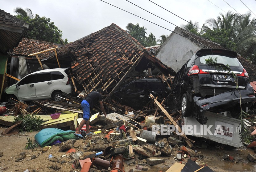 Warga mengais barang diantara reruntuhan di villa Tamaro yang porak poranda diterjang tsunami di Pantai Carita, Pandeglang, Banten, Ahad (23/12/2018). 