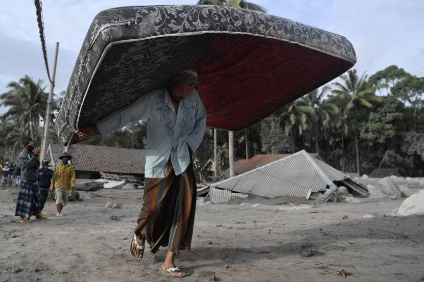 Warga mengamankan kasur dari rumahnya yang rusak akibat diterjang material guguran awan panas Gunung Semeru di Desa Sumber Wuluh, Lumajang, Jawa Timur.