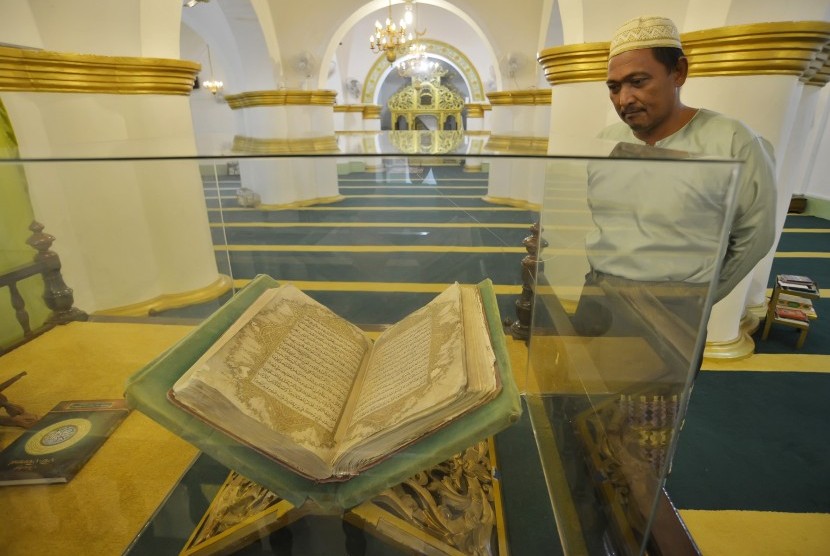 Warga mengamati Al-Quran yang dipajang di Masjid Raya Sultan Riau Pulau Penyengat, Kepulauan Riau, Rabu (24/2).