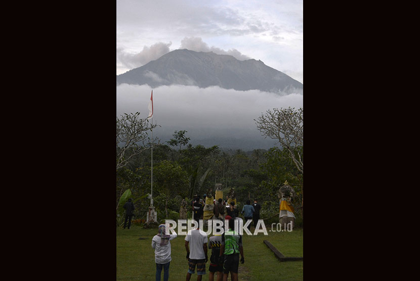 Warga mengamati asap yang mengepul dari kawah Gunung Agung di Pos Pemantauan Gunungapi Agung, Rendang, Karangasem, Bali, Selasa (3/7).