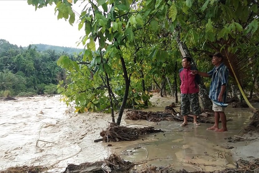 Warga mengamati banjir bandang yang melanda Desa Tuva, kecamatan Gumbasa, Kabupaten Sigi, Sulawesi Tengah, Senin (27/5/2019). 