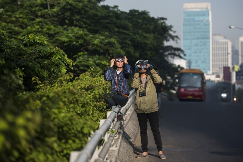 Warga mengamati fase gerhana matahari di kawasan Patung Dirgantara, Pancoran, Jakarta Selatan, Rabu (9/3).