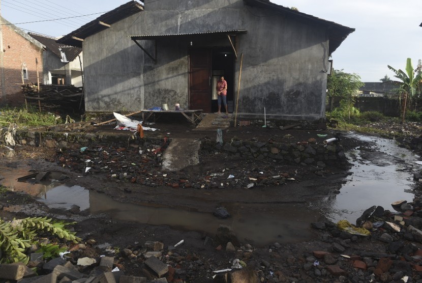 Warga mengamati halaman rumahnya yang rusak akibat banjir di Purwosari, Pasuruan, Jawa Timur, Jumat (6/1).