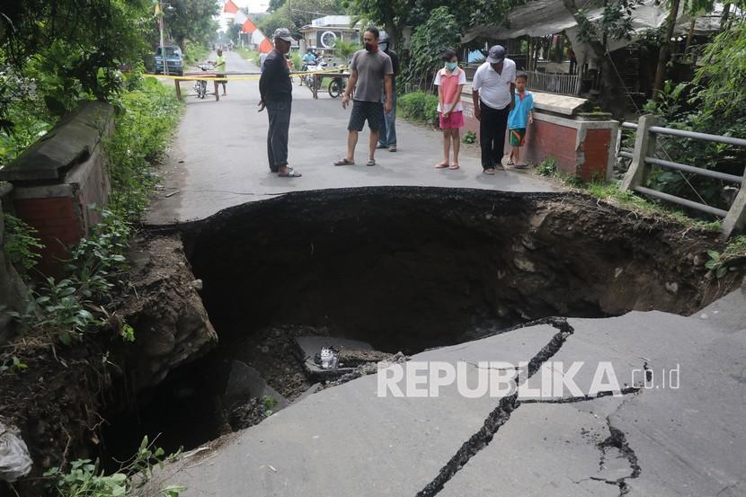 Warga mengamati jembatan rusak (ilustrasi)