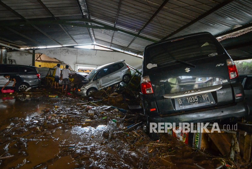 Warga mengamati kendaraan yang terseret banjir bandang di Cicaheum, Bandung, Jawa Barat, Selasa (20/3). 