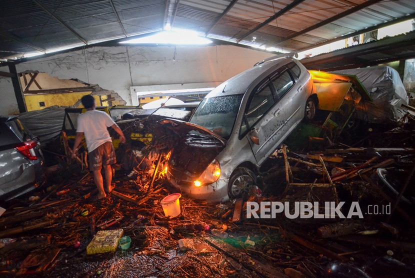 Warga mengamati kendaraan yang terseret banjir bandang di Cicaheum, Bandung, Jawa Barat, Selasa (20/3). 