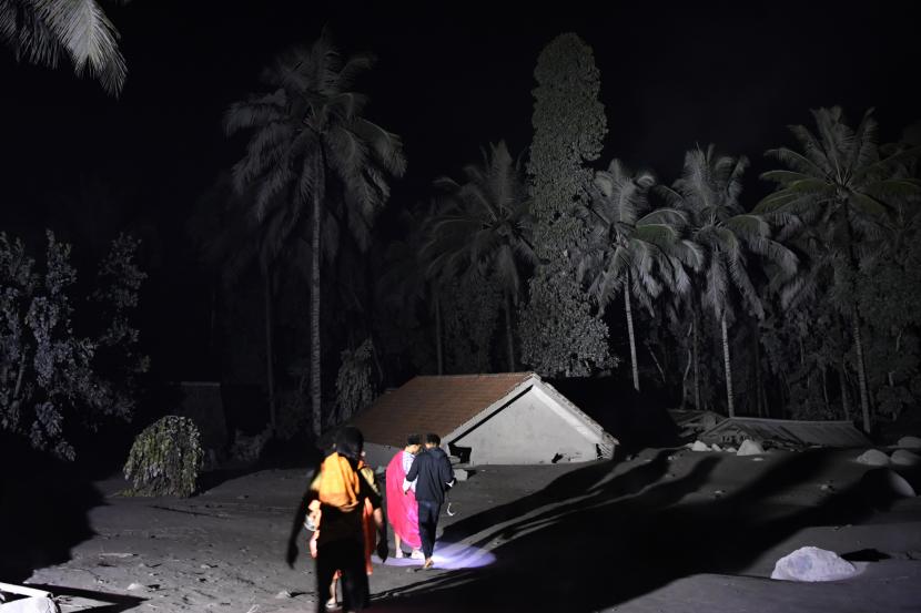 Warga mengamati kondisi rumah yang tertimbun abu vulkanik dari guguran awan panas Gunung Semeru. Petugas berusaha mengevakuasi warga dari Curah Kobokan dengan bantuan dari komunitas pengguna Jeep.