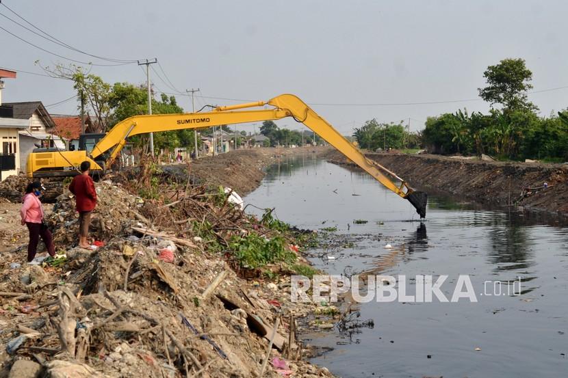 Warga mengamati pengerukan endapan lumpur di kali di Kabupaten Bekasi, Jawa Barat, Rabu (8/9). Pengerukan untuk normalisasi kali di Kampung Pasir Batu hingga Muara Laut Desa Segara Makmur tersebut guna menanggulangi banjir. 