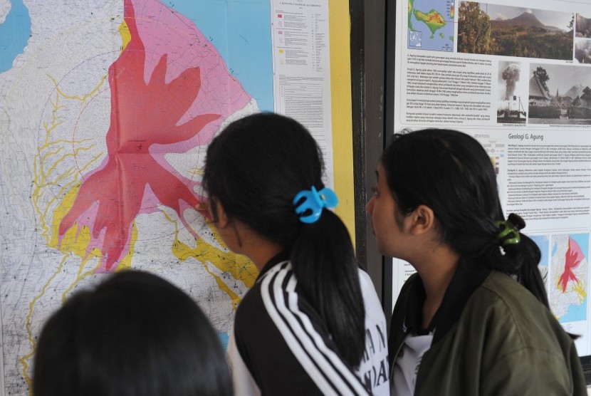 Warga mengamati peta bencana saat turut memantau aktifitas Gunung Agung di Pos Pemantauan Desa Rendang, Karangasem, Bali, Selasa (19/9). 