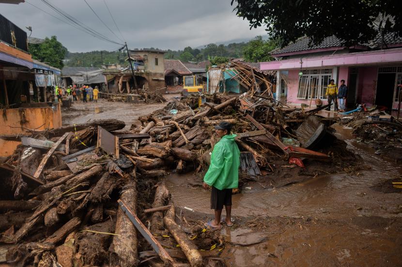 Warga mengamati proses evakuasi akibat banjir bandang di Kampung Cibuntu, Desa Pasawahan, Kecamatan Cicurug, Kabupaten Sukabumi, Jawa Barat.