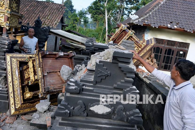 Warga mengamati puing-puing bangunan tempat ibadah yang rusak akibat gempa di kawasan Besakih, Karangasem, Bali, Sabtu (16/10/2021). Gempa bumi dengan magnitudo 4,8 SR terjadi di darat pada jarak delapan kilometer barat laut Karangasem dengan kedalaman 10 km pada Sabtu (16/10) pukul 04.18 Wita. 