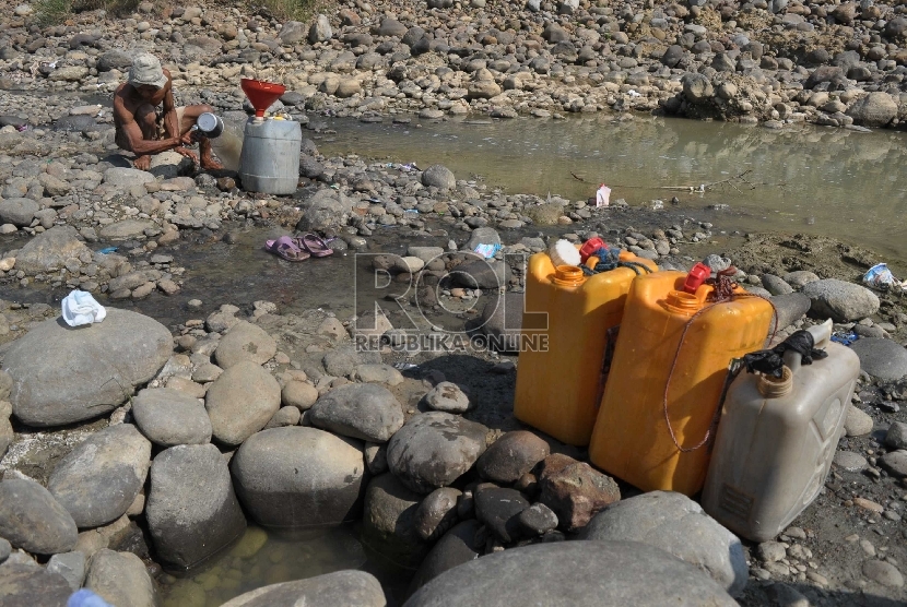 Warga mengambil air dari sumur buatan warga untuk kebutuhan rumah tangga di Kali Cipamingkis, Bekasi, Jawa Barat, (29/07).