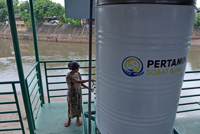 Warga mengambil air untuk diminum dari faslitas filter air bersih di Sungai Ciliwung kawasan Bidara Cina, Jakarta, Selasa (12/1).