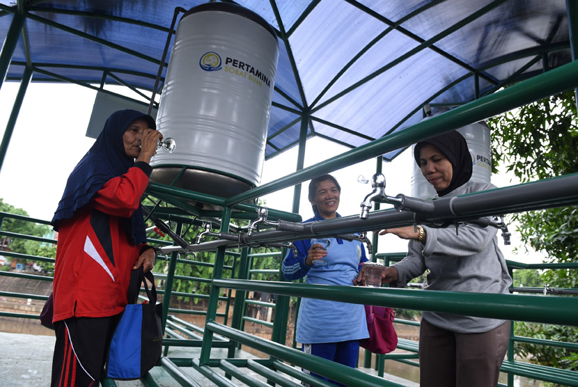 Warga mengambil air untuk diminum dari faslitas filter air bersih di Sungai Ciliwung kawasan Bidara Cina, Jakarta, Selasa (12/1).