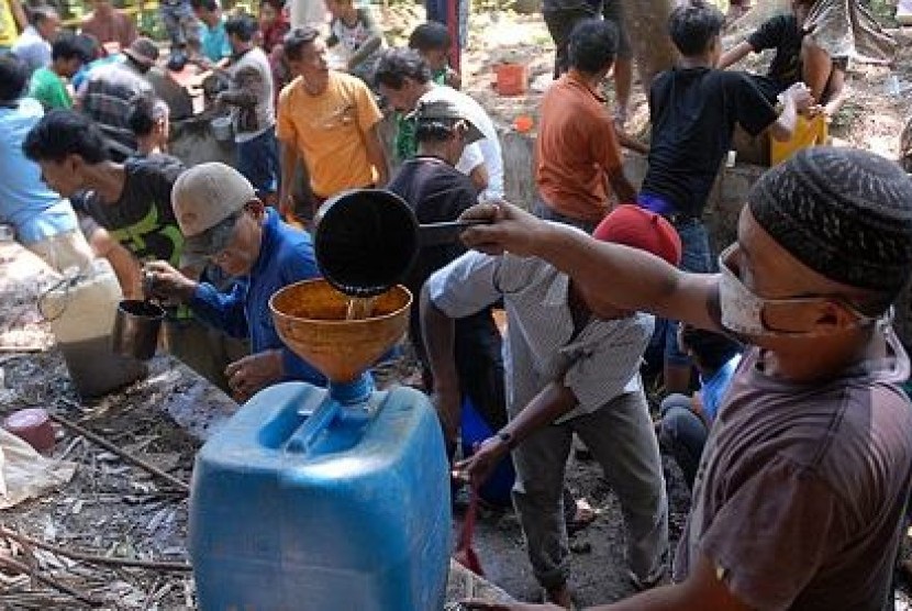 Warga mengambil bahan bakar minyak (BBM) di sekitar jalur pipa milik Pertamina yang bocor di Desa Pasir Batang, Manonjaya, Tasikmalaya, Jawa Barat, (30/7/2013), sebelum akhirnya dilarang oleh Polisi.