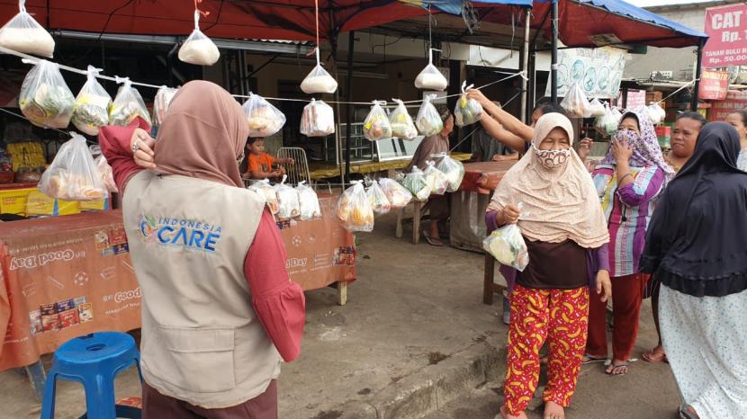 Warga mengambil bantuan pangan dalam program Gerakan Saling Berbagi Indonesia Care di Pamulang, Tangerang Selatan, Jumat (25/9).