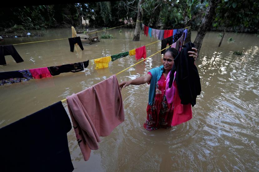 Warga mengambil pakaian yang dijemur saat banjir (ilustrasi)