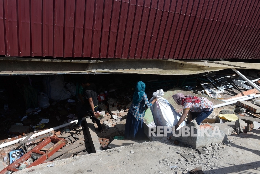  Warga mengambil sisa barang saat evakuasi korban di reruntuhan ruko di Pasar Meureudu, Pidie Jaya, NAD, Kamis (8/12).