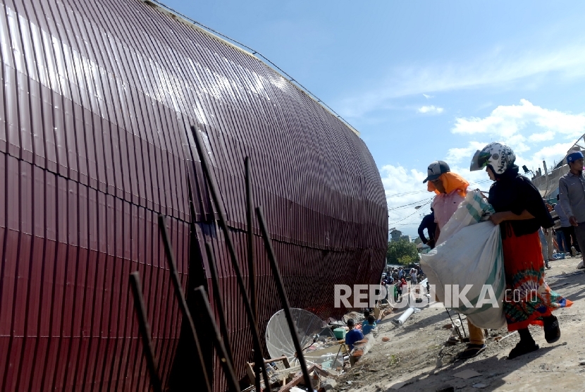  Warga mengambil sisa barang saat evakuasi korban di reruntuhan ruko di Pasar Meureudu, Pidie Jaya, NAD, Kamis (8/12).