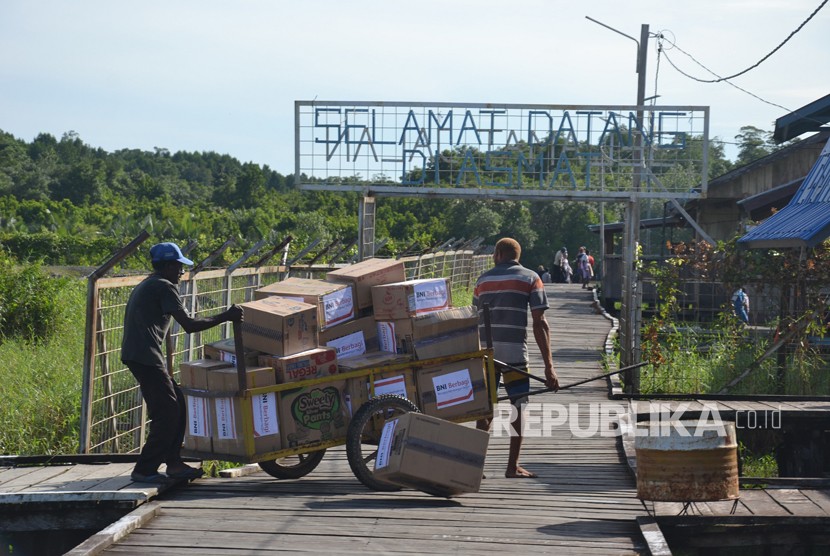 Warga mengangkut bantuan dari Bandara Ewer, Kabupaten Asmat guna disalurkan ke warga terdampak kekurangan gizi dan wabah campak, Kamis (25/1).