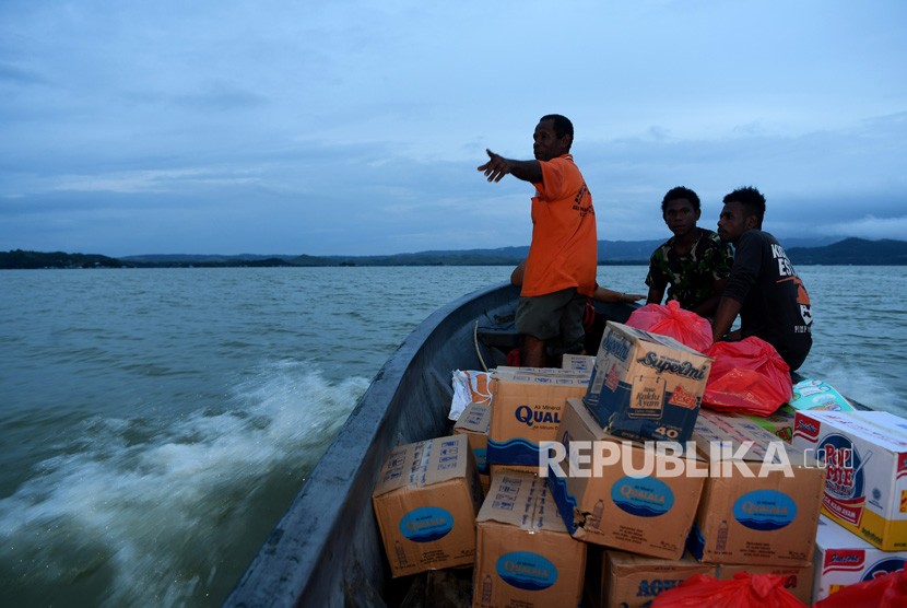 Warga mengantarkan bantuan mengggunakan perahu ke tempat pengungsian di sekitar Danau Sentani di Kampung Yamin di Sentani, Jaya Pura, Papua, Rabu (20/3/2019).