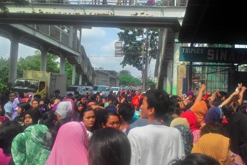 Warga mengantre dalam acara sembako murah yang digelar di Jalan Ngurah Rai, Kp. Sumur, Klender, Jakarta Timur, Jumat (14/4).