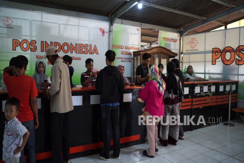 Warga mengantre di kantor pos untuk mengambil bantuan subsidi upah.